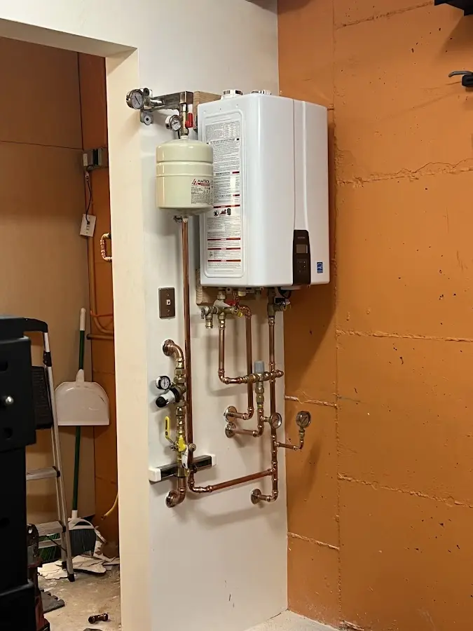 Plumbing technician inspecting water heater connections in Alexander